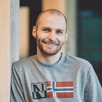 Smilende person som ser inn i kameraet